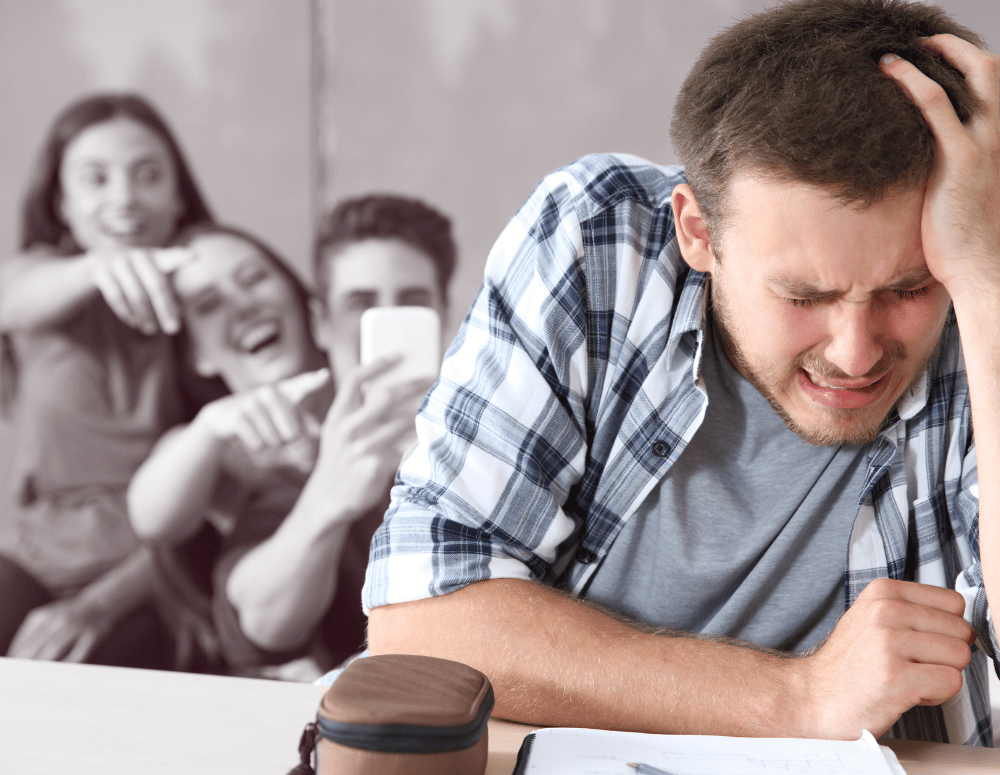 Teen boy looks upset while teens behind him point